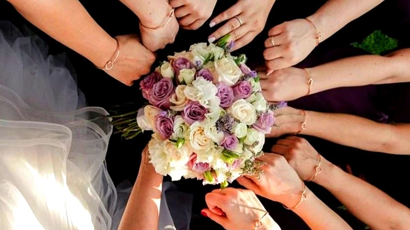 bridesmaid posing to show same piece of jewellry in hand